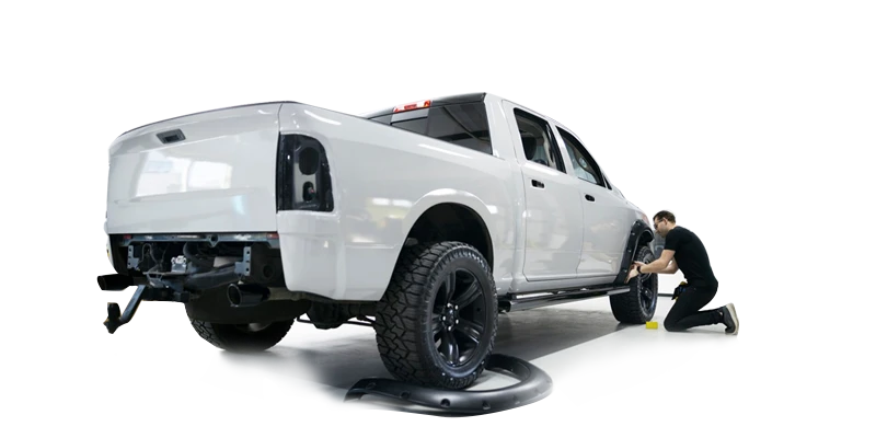 All Star Detail technician detailing the wheel of a white pickup truck
